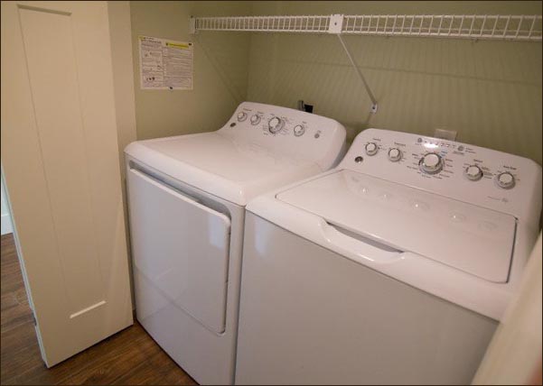 Laundry area features a full sized washer and dryer.
