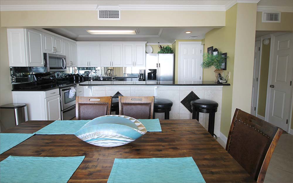 Adjacent the kitchen, a generous dining area overlooks the Gulf of Mexico and Edgewater Beach Resort's gardens, pool, beach and emerald water .