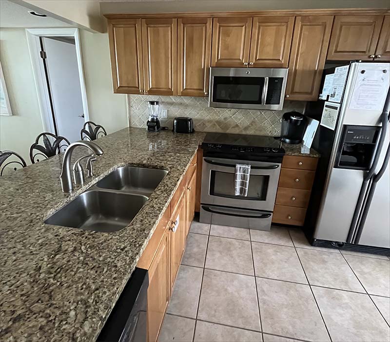 Generouse stainles steel kitchen, granite countertops and seat up to the breakfast bar tile floors and large side-by-side fridge with water dispenser..