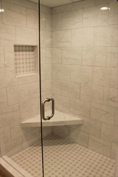 En suite bathroom with twin vanities, mirrored closets and shower.