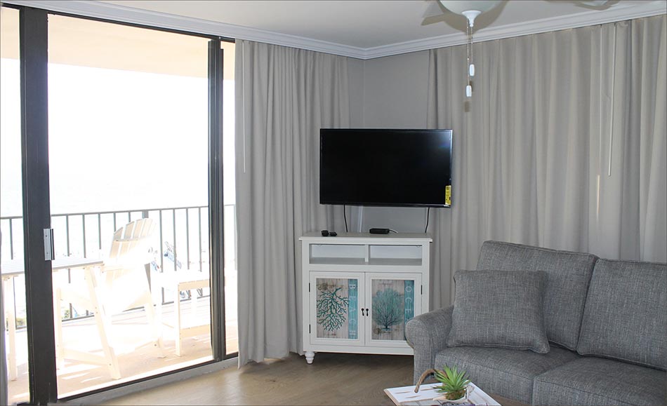 Casual yet contemporary living room furnishings with large flat screen tv, and stunning 7th floor beach and gulf views.