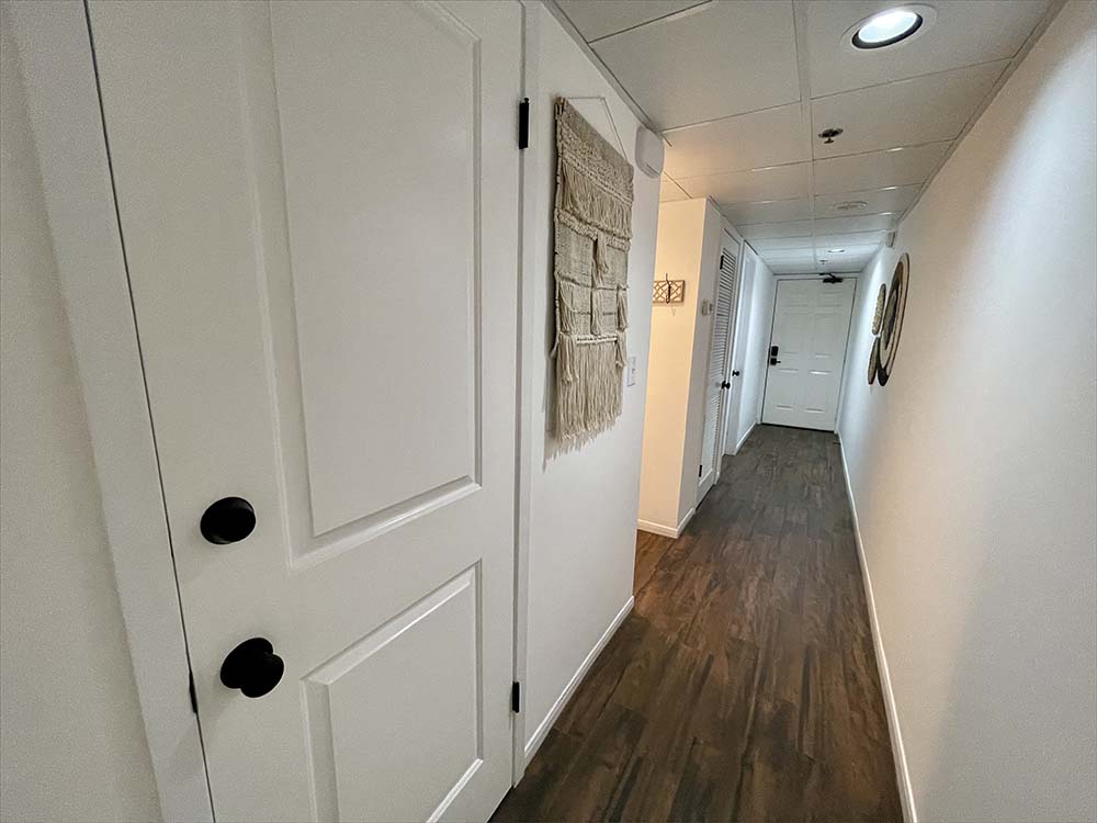Hallway leading to master bedroom and front door.