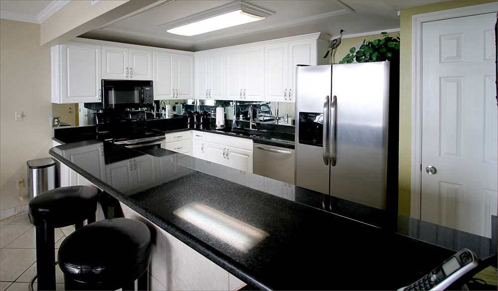 Fully equipped kitchen with stainless steel refridgerator.