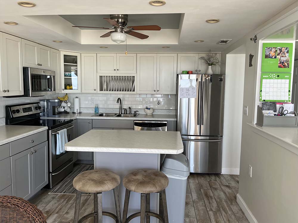 A beautifully equipped kitchen of with stainless steel appliances, cooking and serving ware.