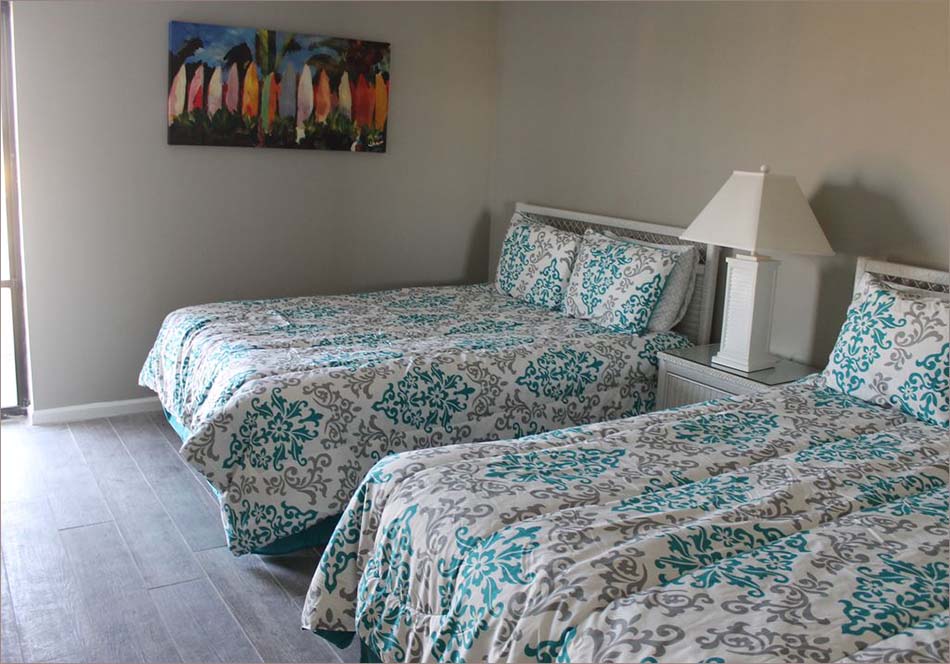 The guestroom features 2 queen beds for 4 additional guests.