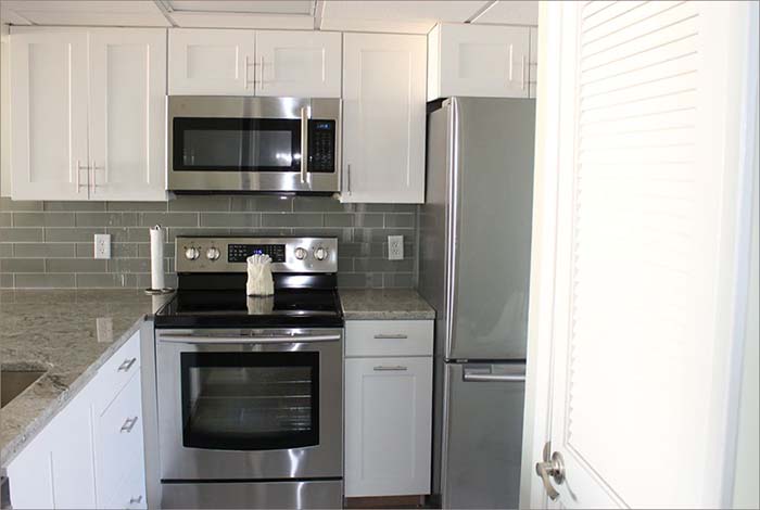 New, stainless steel kitchen with granite countertops, updated cooking and servingware.