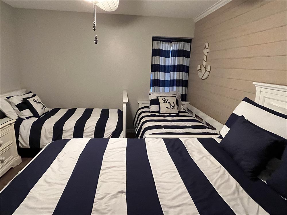 Queen bed and 2 single bunk beds in the third guestroom of this Edgewater luxury condo rental.