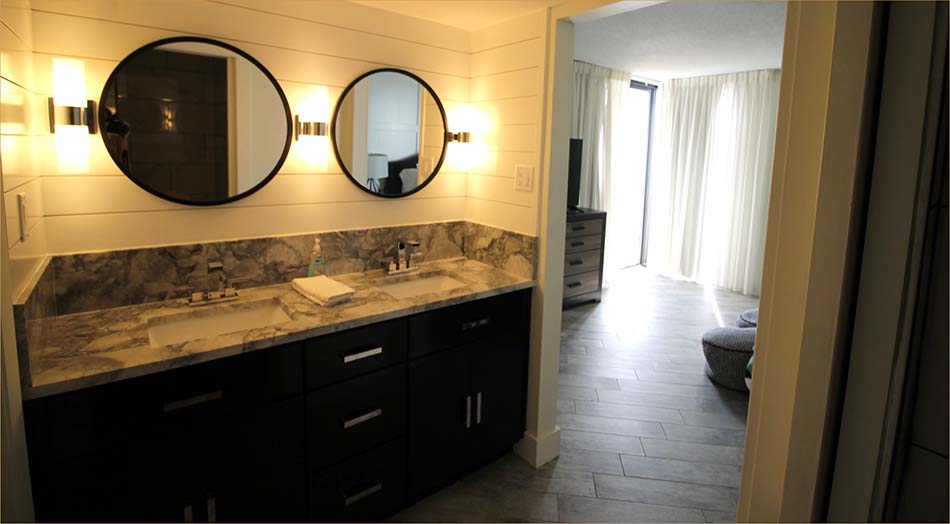 Master bedroom includes a private bathroom with twin vanieties and sink basins.